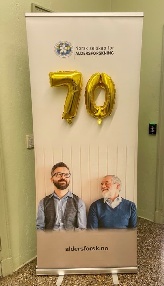 Roll-up med NSA-logoen og gullballonger formet som tallet 70